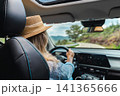 Woman driving car on winding mountain route viewed from passenger perspective 141365666