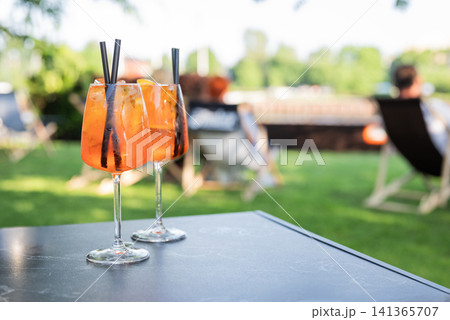 A refreshing close-up of two bright orange Aperol Spritz cocktails in large wine glasses A refreshing close-up of two bright orange Aperol Spritz cocktails in large wine glasses 141365707