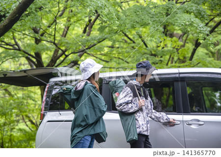 自動車でキャンプに向かう若い男女 141365770