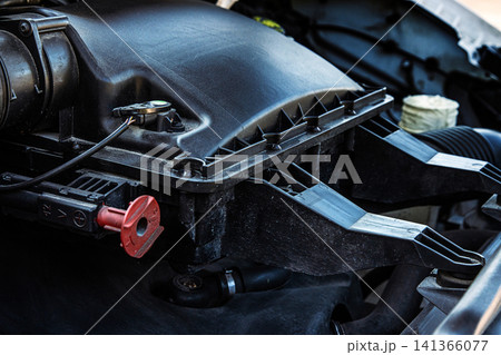 Closeup of a car engine air intake system. Automobile engine compartment with air filter housing. Vehicle maintenance, auto parts,  engineering and transportation technology concept 141366077