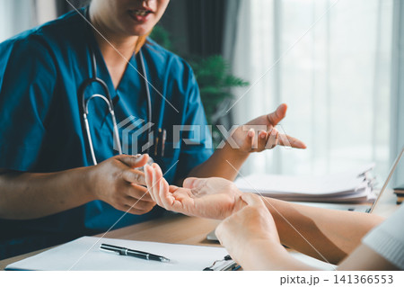 Doctor examining patient hands and explaining symptoms during clinic consultation, healthcare checkup, medical diagnosis, treatment advice, and patient care concept. Doctor examining patient hands and explaining symptoms during clinic consultation, healthcare checkup, medical diagnosis, treatment advice, and patient care concept. 141366553