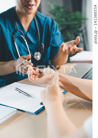Doctor explaining hand and wrist symptoms to patient during clinic consultation, medical examination, diagnosis, treatment advice, and patient care concept. Doctor explaining hand and wrist symptoms to patient during clinic consultation, medical examination, diagnosis, treatment advice, and patient care concept. 141366554