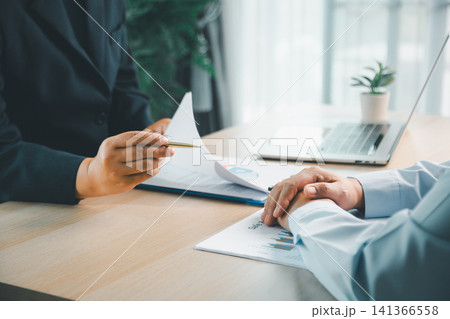 Financial advisor consulting client with sales report and business documents in modern office, representing corporate planning, investment review and professional discussion. Financial advisor consulting client with sales report and business documents in modern office, representing corporate planning, investment review and professional discussion. 141366558