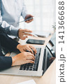 Business team using laptop and digital tablet during office meeting, representing teamwork, business technology, data review and financial planning. 141366688