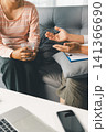 Female client holds water while therapist gestures during counseling consultation, showing calm support, mental health care, wellness advice, stress relief, professional guidance, and trust indoors. 141366690