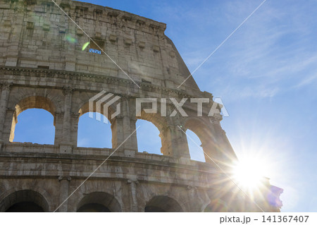 Famous Coliseum in Rome. Colosseum, or Coliseum. Sunset at huge Roman amphitheatre, Rome, Italy, Europe. Famous touristic place in the world and Europe. Beautiful blue sky background. Famous Coliseum in Rome. Colosseum, or Coliseum. Sunset at huge Roman amphitheatre, Rome, Italy, Europe. Famous touristic place in the world and Europe. Beautiful blue sky background. 141367407