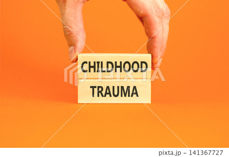 Childhood trauma words symbol. Concept words Childhood trauma on beautiful wooden blocks. Beautiful orange background. Psychologist hand. Psychological childhood trauma support concept. Copy space. 141367727