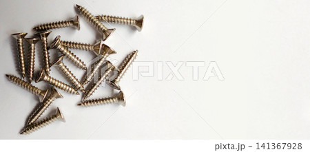 A group of silver wood screws against a plain, bright background. A group of silver wood screws against a plain, bright background. 141367928