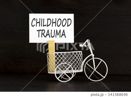 Childhood trauma words symbol. Concept words Childhood trauma on beautiful white paper on wooden clothespin. Beautiful black background. Psychological childhood trauma support concept. Copy space. 141368036