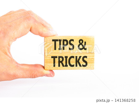 Tips and tricks words symbol. Concept words Tips and tricks on beautiful wooden blocks. Beautiful white background. Businessman hand. Business tips and tricks motivational support concept. Copy space Tips and tricks words symbol. Concept words Tips and tricks on beautiful wooden blocks. Beautiful white background. Businessman hand. Business tips and tricks motivational support concept. Copy space 141368258