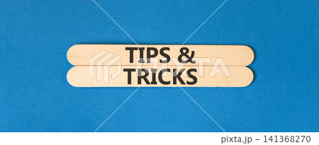 Tips and tricks words symbol. Concept words Tips and tricks on beautiful wooden sticks. Beautiful blue background. Business tips and tricks motivational support concept. Copy space. 141368270