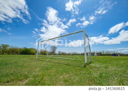 football goal with net on field with green grass football goal with net on field with green grass 141368625