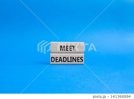 Meet Deadlines symbol. Concept word Meet Deadlines on wooden blocks. Beautiful blue background. Business and Meet Deadlines concept. Copy space Meet Deadlines symbol. Concept word Meet Deadlines on wooden blocks. Beautiful blue background. Business and Meet Deadlines concept. Copy space 141368894