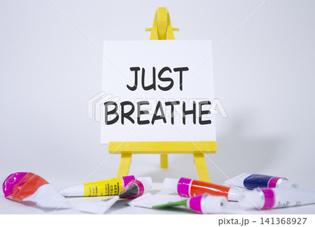Just Breathe symbol. Wooden blocks with words Just Breathe. Beautiful white background with paints and easel. Business and Just Breathe concept. Copy space. Just Breathe symbol. Wooden blocks with words Just Breathe. Beautiful white background with paints and easel. Business and Just Breathe concept. Copy space. 141368927