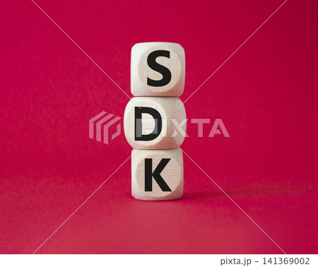 SDK - software development kit. Wooden cubes with word SDK . Beautiful red background. Business and software development kit concept. Copy space. SDK - software development kit. Wooden cubes with word SDK . Beautiful red background. Business and software development kit concept. Copy space. 141369002