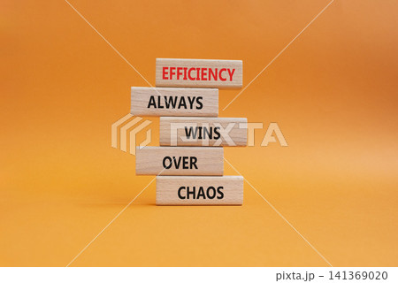 Efficiency symbol. Wooden blocks with words Efficiency Always Wins Over Chaos. Beautiful orange background. Businessman hand. Business and Efficiency concept. Copy space Efficiency symbol. Wooden blocks with words Efficiency Always Wins Over Chaos. Beautiful orange background. Businessman hand. Business and Efficiency concept. Copy space 141369020