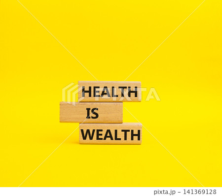Health is Wealth symbol. Concept word Health is Wealth on wooden blocks. Beautiful yellow background. Medicine and Health is Wealth concept. Copy space 141369128