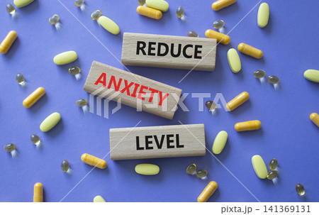Reduce Anxiety Levels symbol. Concept words Reduce Anxiety Level on wooden blocks. Beautiful purple background with pills. Healthcare and Reduce Anxiety Levels concept. Copy space. Reduce Anxiety Levels symbol. Concept words Reduce Anxiety Level on wooden blocks. Beautiful purple background with pills. Healthcare and Reduce Anxiety Levels concept. Copy space. 141369131