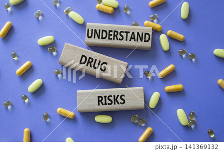 UNDERSTAND DRUG RISKS symbol. Concept words UNDERSTAND DRUG RISKS on wooden blocks. Beautiful purple background with pills. Healthcare and UNDERSTAND DRUG RISKS concept. Copy space. UNDERSTAND DRUG RISKS symbol. Concept words UNDERSTAND DRUG RISKS on wooden blocks. Beautiful purple background with pills. Healthcare and UNDERSTAND DRUG RISKS concept. Copy space. 141369132