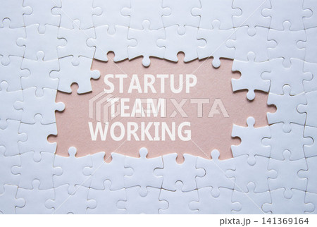 Startup Team Working symbol. White puzzle with words Startup Team Working. Beautiful pink background. Business concept. Copy space. 141369164