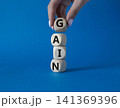 Gain symbol. Concept word Gain on wooden cubes. Businessman hand. Beautiful blue background. Business and Gain concept. Copy space. 141369396