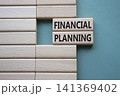 Financial Planning symbol. Concept word Financial Planning on wooden blocks. Beautiful grey green background. Business and Financial Planning concept. Copy space 141369402