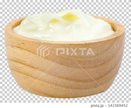 Creamy white yogurt with yellow fruit chunks served in a small round wooden bowl isolated. Healthy dairy product, breakfast snack, or cooking ingredient concept. 141369452