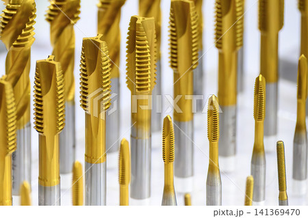 Close-up of a group of special coating tapping tools for small and big size threads for CNC milling machines. Close-up of a group of special coating tapping tools for small and big size threads for CNC milling machines. 141369470