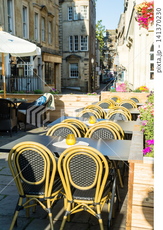 朝日の下の店先に並べられた椅子とテーブル　イギリスの世界遺産に登録されたバースの街並み 141370230