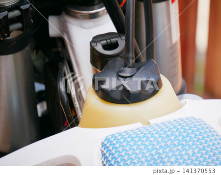 Fuel reservoir with black cap on sport motorcycle vehicle. Transportation mechanical component of motorbike engine. Technical repair and maintenance concept for automotive equipment detail. Fuel reservoir with black cap on sport motorcycle vehicle. Transportation mechanical component of motorbike engine. Technical repair and maintenance concept for automotive equipment detail. 141370553