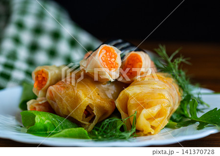 Delicious marinated cabbage rolls served with fresh lettuce leaves Delicious marinated cabbage rolls served with fresh lettuce leaves 141370728