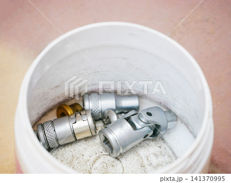 Metal socket set inside a white plastic container. Assorted steel tools for mechanical maintenance and automotive repair. Equipment for fixing hardware and mechanical engineering project. 141370995