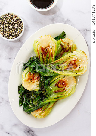 Grilled bok choy served with soy sauce and sesame seeds, on a white plate, homemade, no people, 141371238