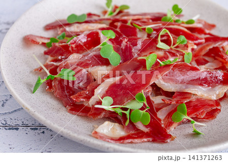 Ham of duck breast,dried duck fillet, with microgreens,plate, on a tiled table, Ham of duck breast,dried duck fillet, with microgreens,plate, on a tiled table, 141371263