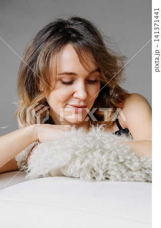 Dreamy woman. Home comfort. Happy smiling female relaxing on white sofa resting on cozy cushion enjoying peaceful daily lifestyle. Dreamy woman. Home comfort. Happy smiling female relaxing on white sofa resting on cozy cushion enjoying peaceful daily lifestyle. 141371441