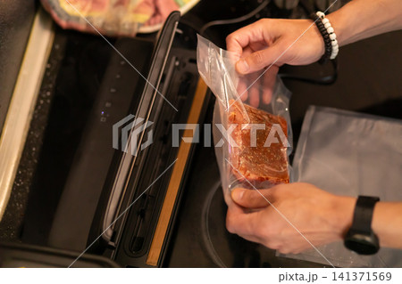 Two Hands Removing Vacuum Sealed Pork From Sealer Machine Two Hands Removing Vacuum Sealed Pork From Sealer Machine 141371569