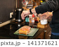 Chef Salting Marinated Pork Loin on Board Near Vacuum Sealer 141371621
