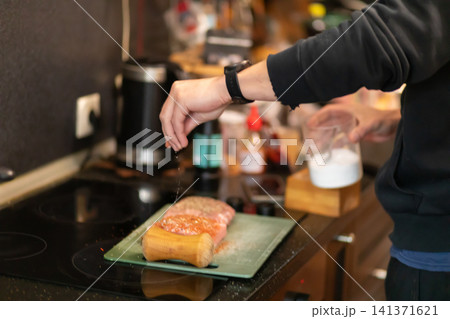 Chef Salting Marinated Pork Loin on Board Near Vacuum Sealer Chef Salting Marinated Pork Loin on Board Near Vacuum Sealer 141371621