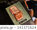 Overhead View Applying Red Spice Rub on Raw Pork Ribs 141371624
