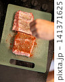 Overhead View Applying Red Spice Rub on Raw Pork Ribs 141371625