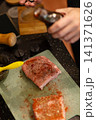 Brushing Dark Marinade Sauce on Seasoned Raw Pork Steak 141371626