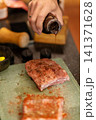Two Marinated Raw Pork Pieces With Red Rub on Cutting Board 141371628