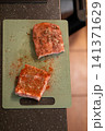 Close Up Raw Pork Rib Piece Covered in Red Paprika Rub 141371629