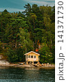 Charming Yellow Cabin on a Rocky Island Coast. A beautiful scenic view of a charming yellow wooden cabin Charming Yellow Cabin on a Rocky Island Coast. A beautiful scenic view of a charming yellow wooden cabin 141371730