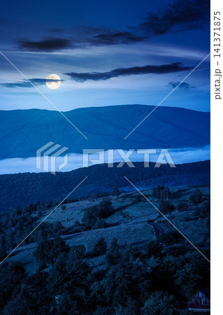 carpathian mountain landscape on a foggy night. outdoor adventure with stunning view. full moon over mountainous countryside of ukraine in summer. mysterious rolling hills carpathian mountain landscape on a foggy night. outdoor adventure with stunning view. full moon over mountainous countryside of ukraine in summer. mysterious rolling hills 141371875