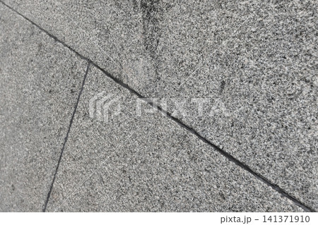 Close-up of diagonal granite tile texture on a gray stone wall showing seams Close-up of diagonal granite tile texture on a gray stone wall showing seams 141371910
