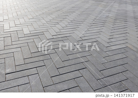 Gray concrete pavers forming a clean Herringbone geometric pattern Gray concrete pavers forming a clean Herringbone geometric pattern 141371917