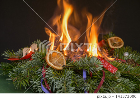 Christmas wreath completely engulfed in open flames after festive decorations caught fire indoors. Christmas wreath completely engulfed in open flames after festive decorations caught fire indoors. 141372000