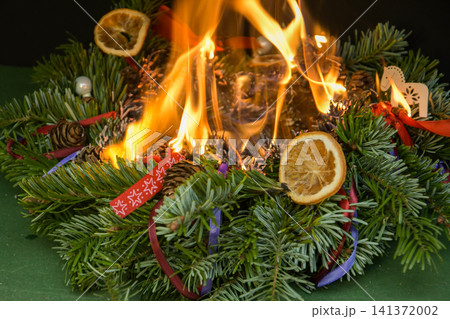 Intense burning of a Christmas wreath demonstrates the danger of using open flames near dry evergreen branches. Intense burning of a Christmas wreath demonstrates the danger of using open flames near dry evergreen branches. 141372002