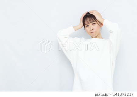 頭を抱えて悩む女性 141372217